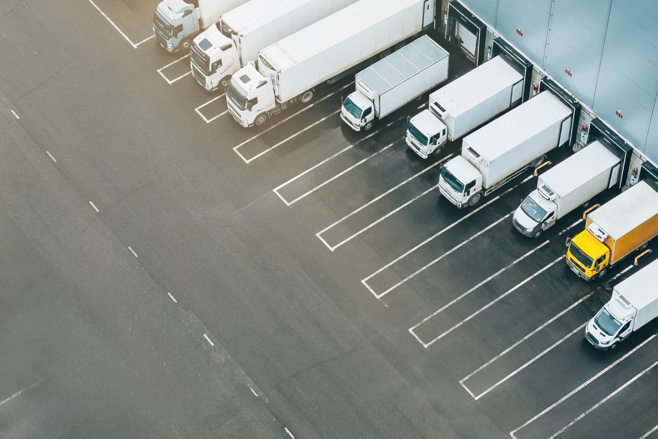 A loading bay with multiple delivery trucks viewed from above